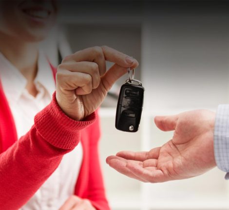 Salesperson handing over car keys to a new car buyer